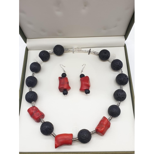 70 - A Hawaiian lava necklace and earrings set, adored with big chunks of Pacific red coral. In a present... 