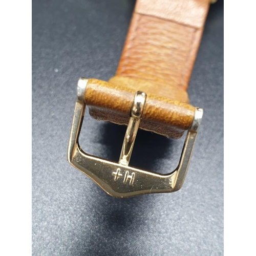 152 - A vintage 14ct gold Junghans men's watch. Gold case with silver dial. Comes with original leather st... 