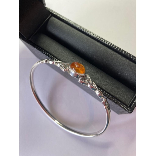 113 - Silver BANGLE having Celtic Knot design to the top with an amber centre stone.  Presented in Jewelle... 