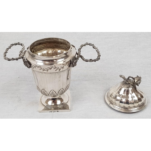 58 - An Antique small Silver Urn. Silver Wire Handles, ribbed body and lid, finished with a wilting Rose ... 