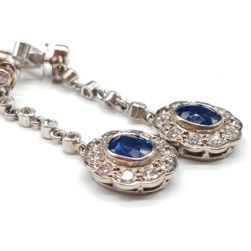 144 - Pair of 14ct White Gold Drop EARRINGS with brilliant cut Diamonds and central Sapphire.   6.6g     3... 