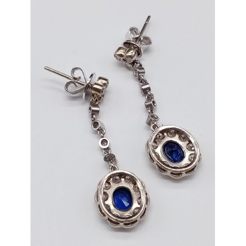 144 - Pair of 14ct White Gold Drop EARRINGS with brilliant cut Diamonds and central Sapphire.   6.6g     3... 