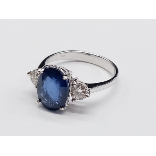 25 - 18ct White Gold RING set with one oval cut natural Sapphire and 2x round brilliant cut natural Diamo... 