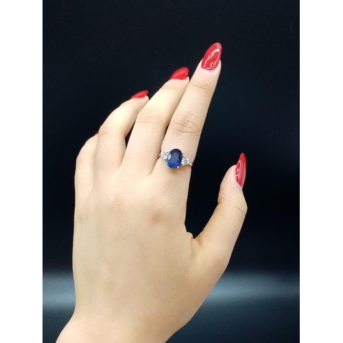 25 - 18ct White Gold RING set with one oval cut natural Sapphire and 2x round brilliant cut natural Diamo... 