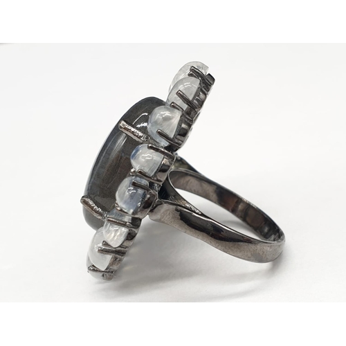 570 - 10.50 Ct Moonstones & 14.25 Ct Labradorite set within a blackened silver ring, weight 11.62g and siz... 