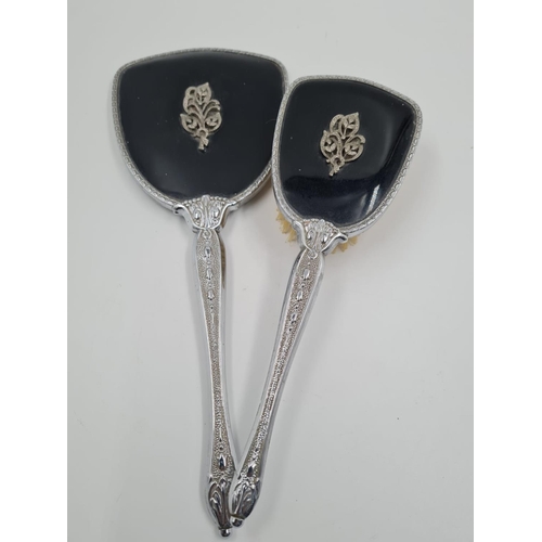 488 - A Vintage Silver-Plate Hand Mirror and Hair Brush. Black back with ornate decoration. Mirror- 32cm. ... 