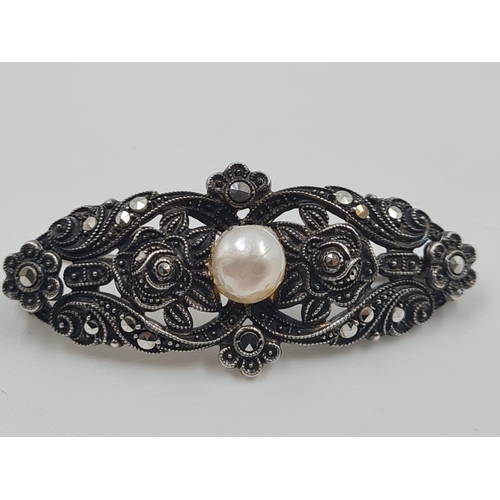 701 - 2 Silver Marcasite Brooches. One with a large Hamethyst the other a Pearl. 4cm. 18g total weight.