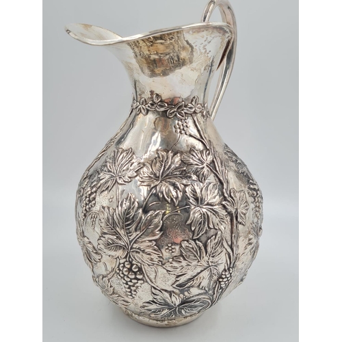 77 - A LARGE SPANISH SILVER WATER JUG HAND FASHIONED CIRCA 1920. 474.4 gms and 27cms TALL