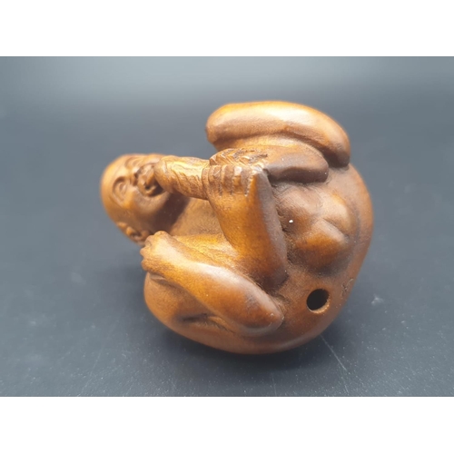 163 - An intricately carved boxwood, Japanese, netsuke of a contortionist man indulging in self-satisfacti... 