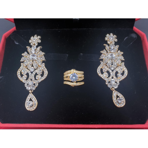 728 - A boxed set of a statement yellow metal triple ring and earrings with cubic zirconia. Ring size: N, ... 