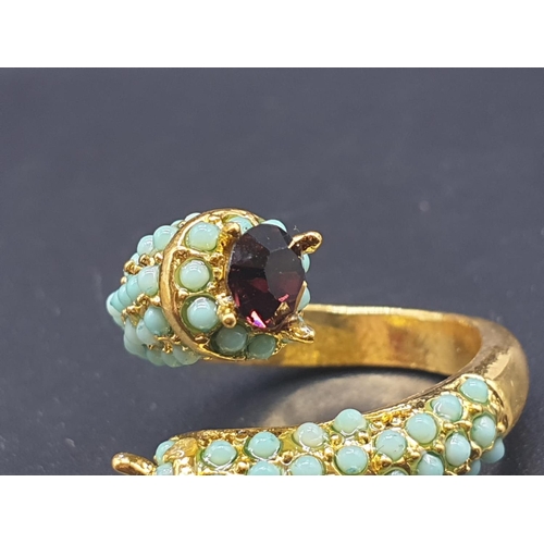 734 - An unusual yellow metal (untested) ring with turquoise and amethysts in its presentation box. Ring s... 