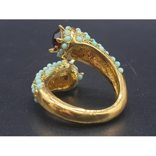 734 - An unusual yellow metal (untested) ring with turquoise and amethysts in its presentation box. Ring s... 