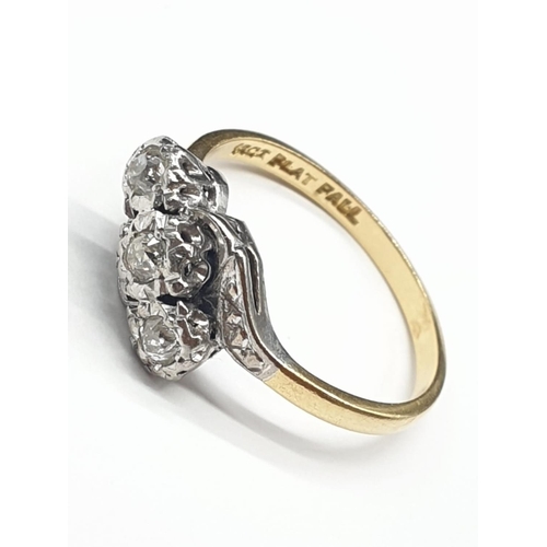 579 - 18ct yellow gold and platinum 3 stone twist ring size N1/2. 0.15ct and weighs 3.2g.