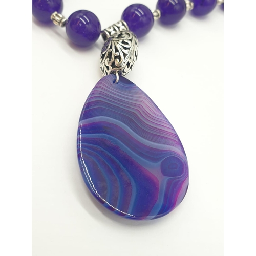 632 - A Tibetan silver with purple jade and agate necklace in a presentation box. Colour enhanced. Necklac... 