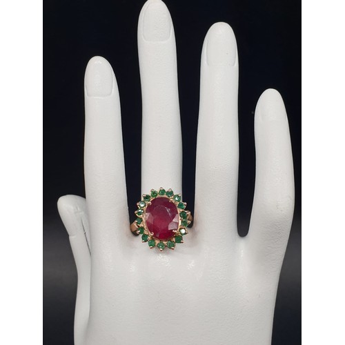 368 - A 9ct Ruby ring with a halo of emerald accents in 925 silver gold plating, weight 8g and size M1/2