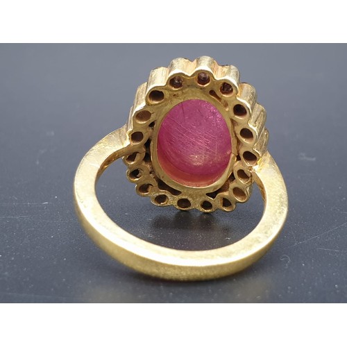 250 - A cabochon ruby gemstone ring with a halo of white diamond accents approx .40ct size O