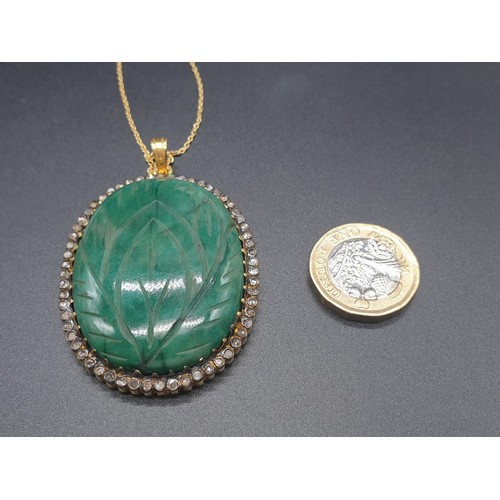 187 - A carved emerald Pendant with a halo of rose cut diamonds in pave setting in sterling silver with go... 