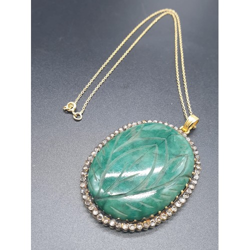 187 - A carved emerald Pendant with a halo of rose cut diamonds in pave setting in sterling silver with go... 