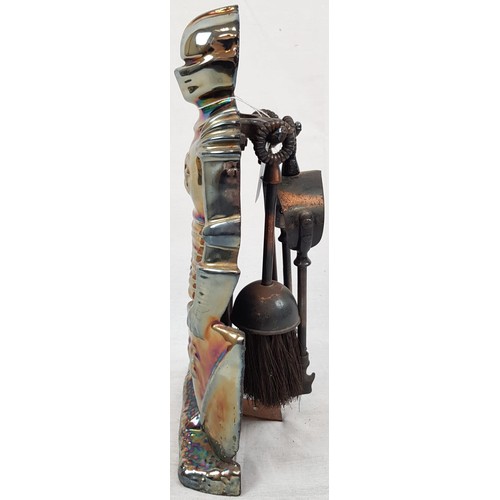 741 - A FIRESIDE SET TO INCLUDE A BRUSH, TONGS AND A POKER HOUSED IN A SUIT OF ARMOUR.
36cms IN HEIGHT.