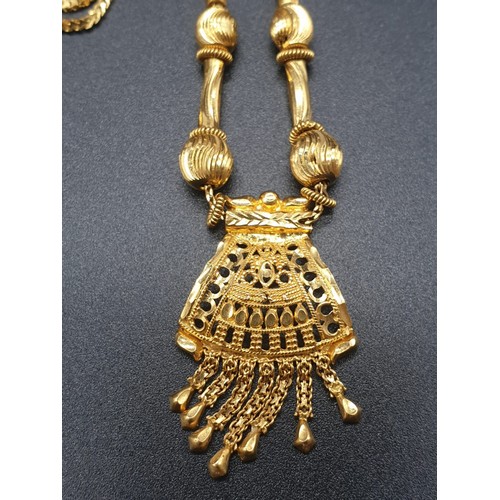 191 - A refined 21 carat yellow gold, Indian style chain with pendant. Chain length:  44cm, total weight: ... 