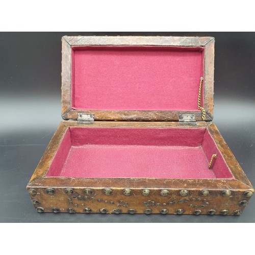 769 - AN ANTIQUE LEATHER BOUND STUDDED TRINKET BOX.
13 X 24CMS