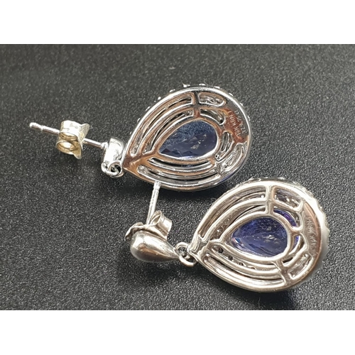 133 - A 14CT WHITE GOLD MATCHING SET OF EARRINGS AND DRESS RING WITH LARGE PEAR SHAPED TANZANITE STONES AN... 