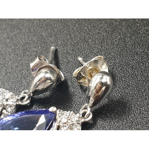 133 - A 14CT WHITE GOLD MATCHING SET OF EARRINGS AND DRESS RING WITH LARGE PEAR SHAPED TANZANITE STONES AN... 