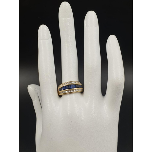 140 - AN 18CT GOLD RING WITH CHANNEL SET DIAMONDS AND SAPHIRES 7.4gms SIZE N