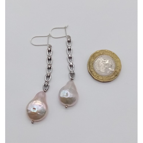 44 - Pair of baroque pearl and diamond drop earrings set in white gold, weight 8.2g and drop 7cm approx