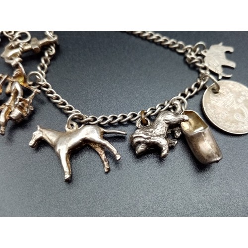 263 - An Antique Sterling Silver Bracelet with Charms.
21cm.  21.67g