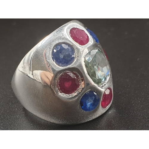 378 - A Cocktail ring with natural rubies and Blue sapphires and a flat blue moissanite in the center. Siz... 