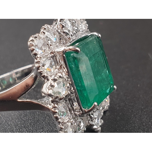 340 - AN 18CT WHITE GOLD RING SET WITH A LARGE EMERALD CUT NATURAL EMERERALD CENTRE STONE AND 16 ROSE CUT ... 