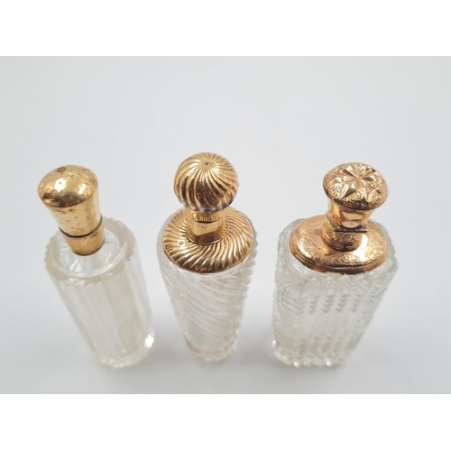 248 - 3 FRENCH 19TH CENTURY CUTGLASS PERFUME BOTTLES WITH 18CT GOLD TOPS, 137.3gms AND 9cms TALL.