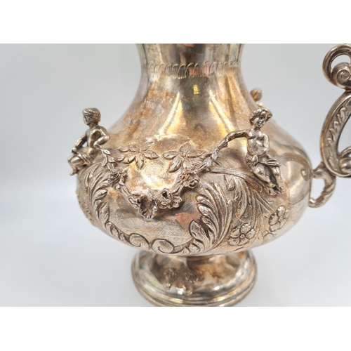 157 - A LARGE SPANISH SILVER ETRUSCAN SHAPED WATER JUG, HAND DECORATED WITH CHERUBS AND FLORA.
1.2kg and 3... 