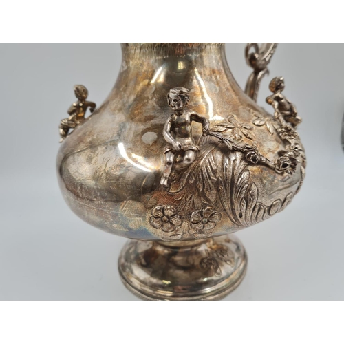 157 - A LARGE SPANISH SILVER ETRUSCAN SHAPED WATER JUG, HAND DECORATED WITH CHERUBS AND FLORA.
1.2kg and 3... 