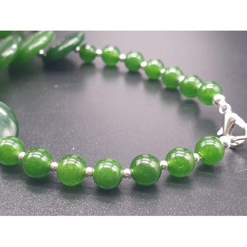 797 - A modern spinach green jade necklace, bracelet and earrings set in a presentation box. Necklace leng... 