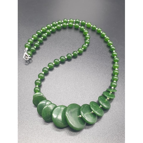 797 - A modern spinach green jade necklace, bracelet and earrings set in a presentation box. Necklace leng... 