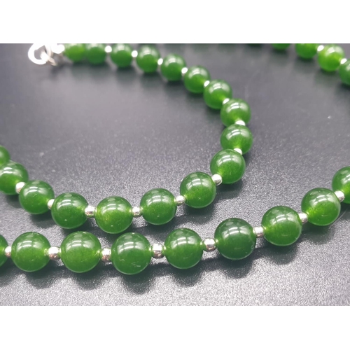 797 - A modern spinach green jade necklace, bracelet and earrings set in a presentation box. Necklace leng... 