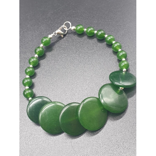 797 - A modern spinach green jade necklace, bracelet and earrings set in a presentation box. Necklace leng... 