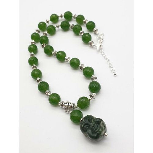 250 - A Tibetan silver and green jade necklace and earrings set with hand carved smiling Buddha head penda... 