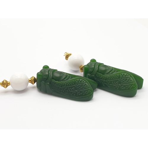 391 - A vintage Chinese white jade beaded necklace with green jade cicadas, in a presentation box. Necklac... 