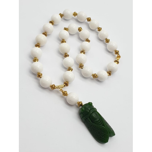 391 - A vintage Chinese white jade beaded necklace with green jade cicadas, in a presentation box. Necklac... 