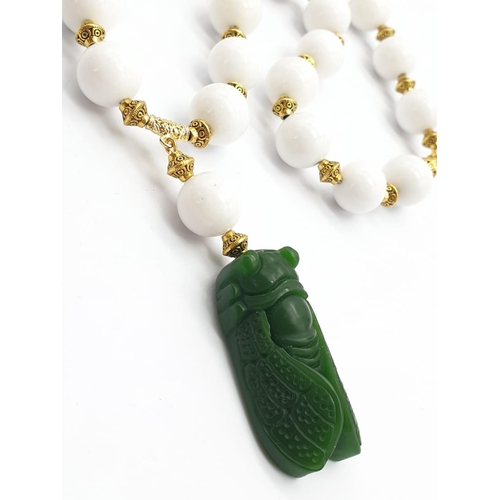 391 - A vintage Chinese white jade beaded necklace with green jade cicadas, in a presentation box. Necklac... 