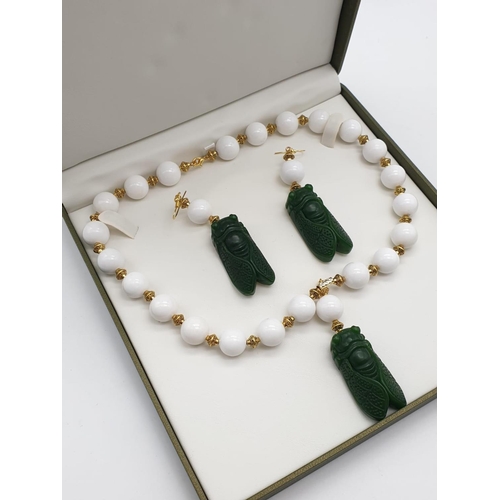 391 - A vintage Chinese white jade beaded necklace with green jade cicadas, in a presentation box. Necklac... 