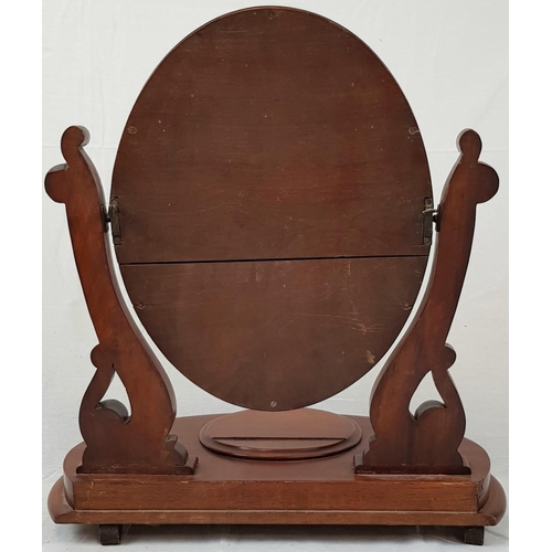 214 - AN OVAL SHAPED FREE STANDING DRESSING TABLE MIRROR WITH HINGED MAKEUP COMPARTMENT.
64 X54cms A/F