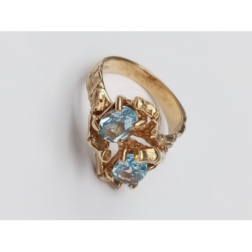 97 - 14k yellow gold crossover ring with blue stones, weight 5.4g and size L