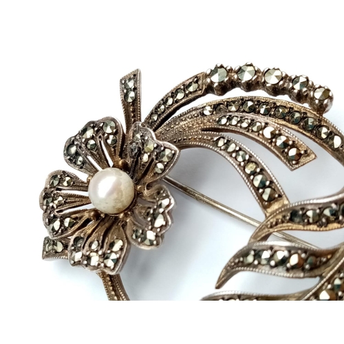 573 - Victorian silver filigree brooch with pearl in floral design, weight 12.7g and 45mm wide approx