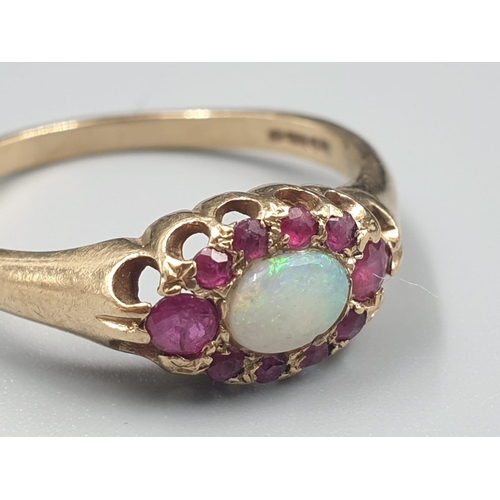 137 - 9K YELLOW GOLD VINTAGE OPAL CENTRE & RUBY SURROUNDS CLUSTER RING WEIGHT 2.2G SIZE O