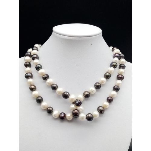 559 - An elegant and very long white and black pearl necklace  82cm long