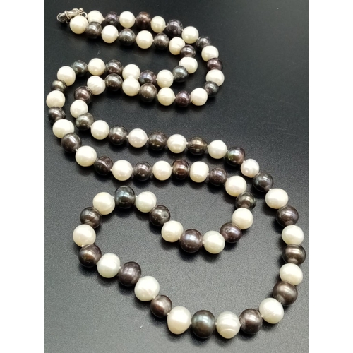 559 - An elegant and very long white and black pearl necklace  82cm long